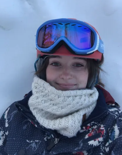Hannah in the snow with a ski helmet on