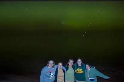 Several students posing for a photo at night