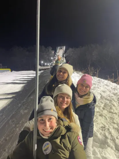 Four women at a ski jump in wintertime 