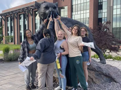 Students touching the nose of the Wildcat statue in the middle of the Academic Mall