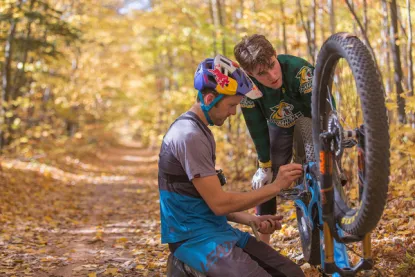 Students working on a mountain bike in the woods