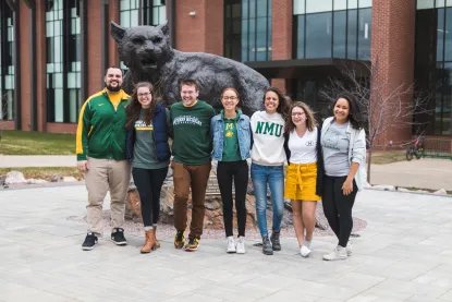 Students standing in front of the wildcat statue