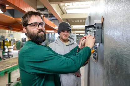 Two male students work on HVAC equipment