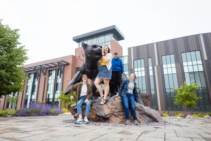 four students with the wildcat statue 
