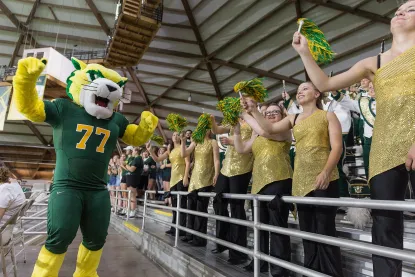 Wildcat Willy cheering in the stands at Northern Michigan University's homecoming game