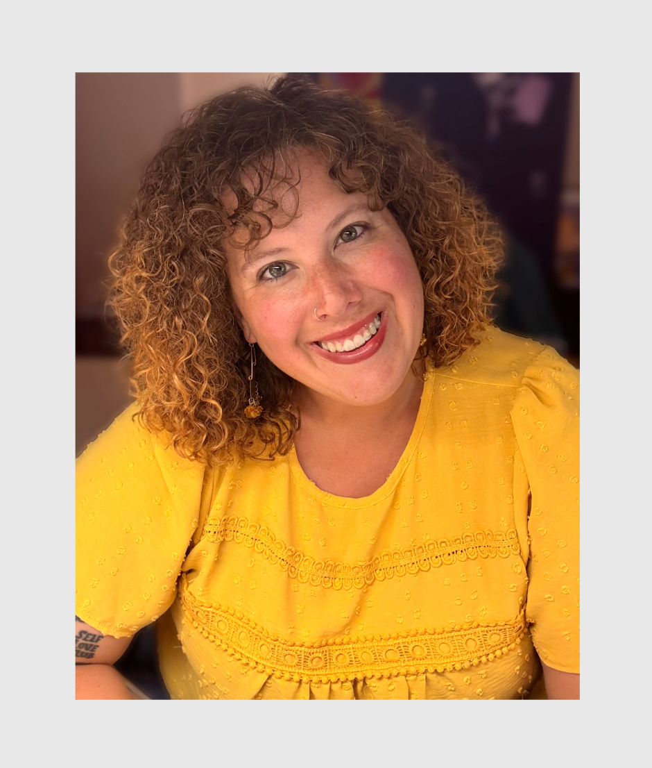 Headshot of smiling woman with curly hair in a yellow top 