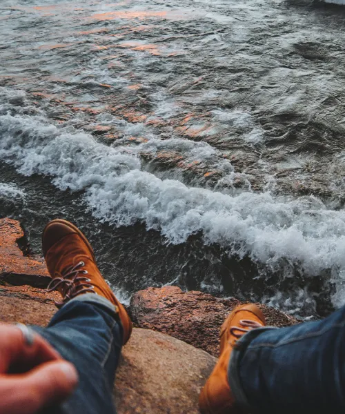 Student's feet in front of Lake Superior