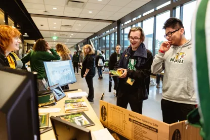 Students gather around a table at the student organization fair in the Northern Center