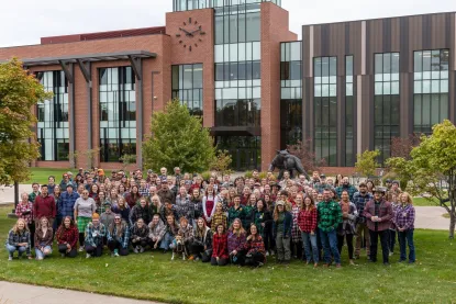 Group of students, faculty, and staff pose in plaid for a campus Plaidurday photo