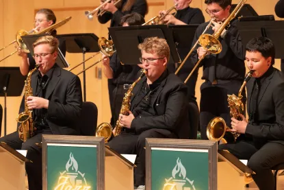 Three gentleman playing the saxophone on stage 
