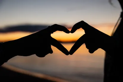 Two hands coming together to form a heart amongst a Lake Superior backdrop