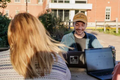 Students studying outside on their laptops