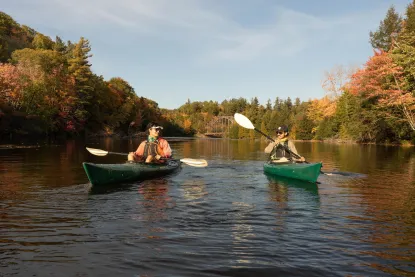 Two people kayaking on a fall day.