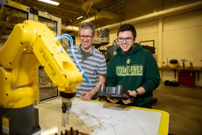 Professor and student working with robotic arm