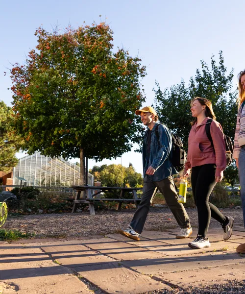 Three students walking on NMU's campus. 
