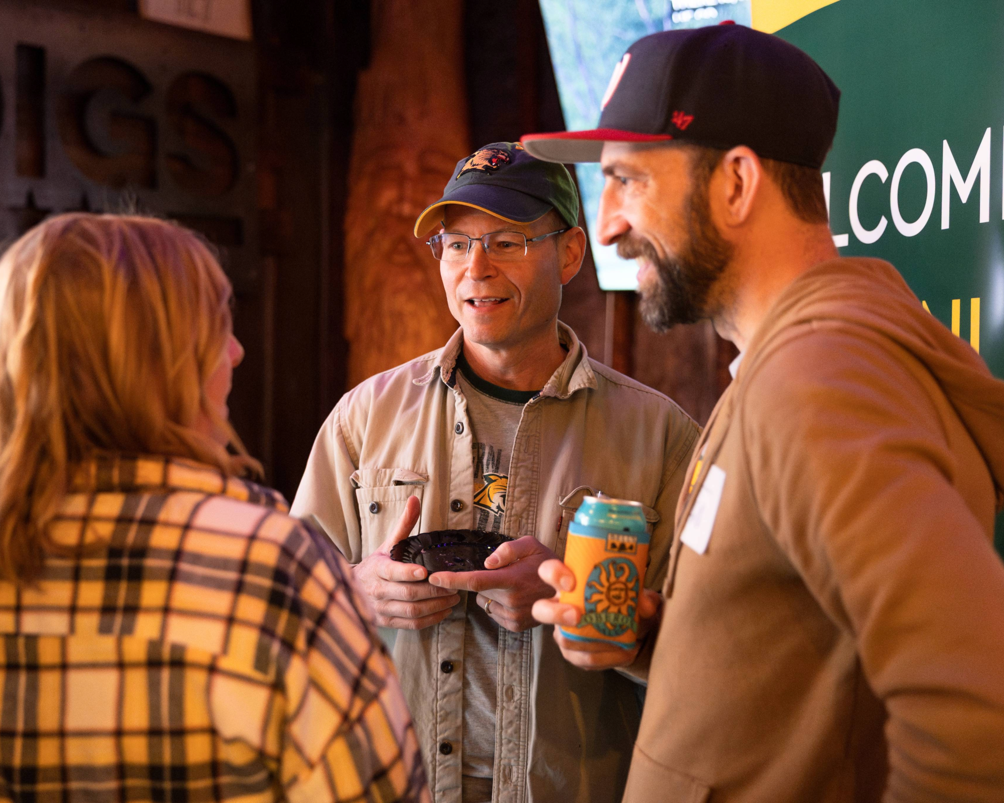 Three alumni talking during a happy hour event.