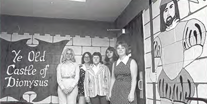 Four people in front of a painted mural