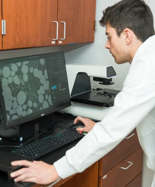 Male student doing cell research on a computer