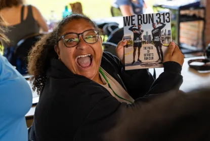 Woman excitedly holding up the keynote speakers book, "Re Run 313"