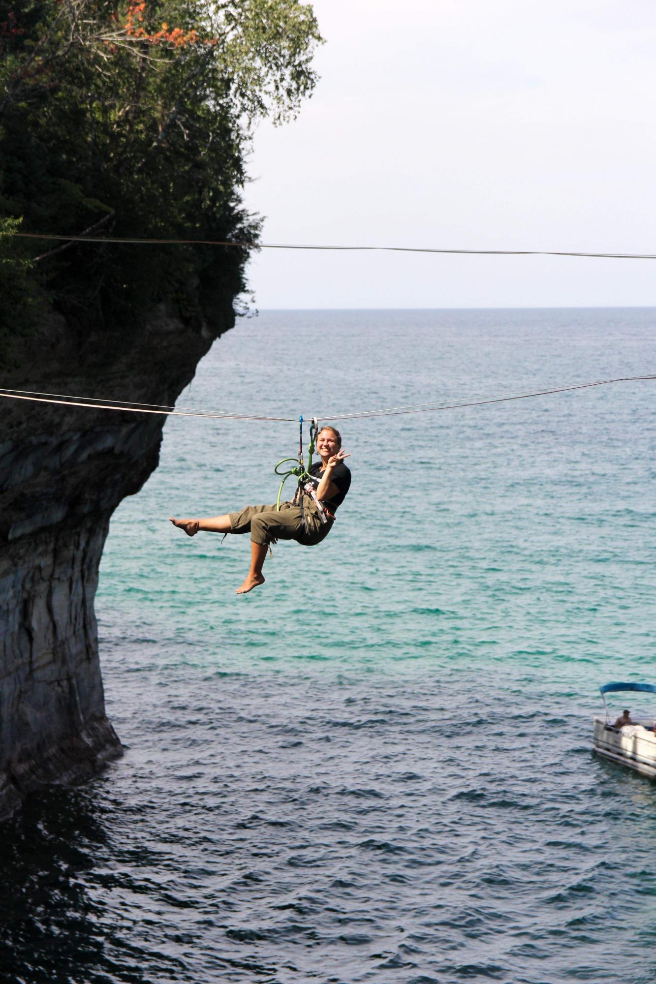 Zoe hanging on slack line over the water