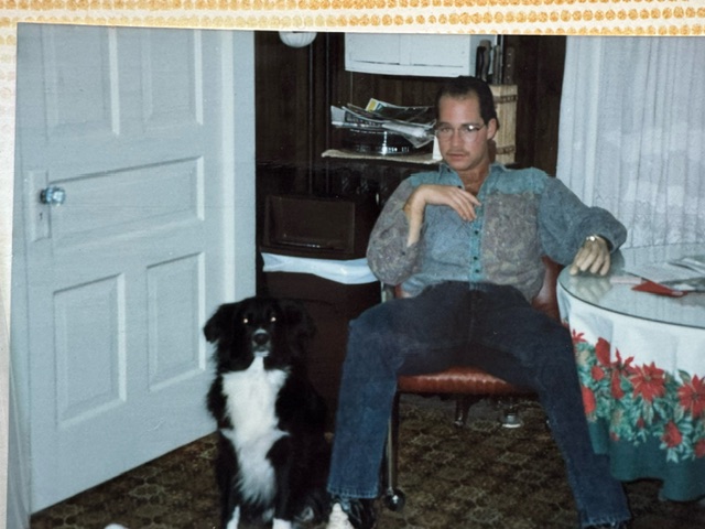 Man sitting next to his dog