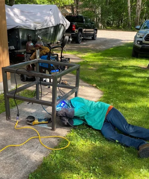 Man on ground welding