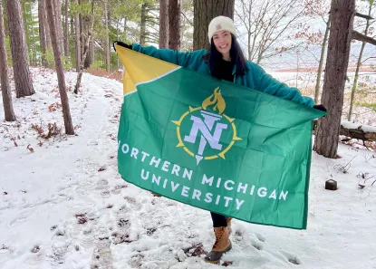 Liz holding an NMU flag outside