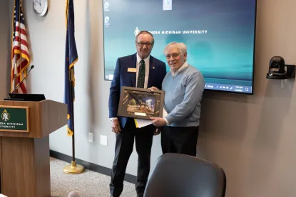 Stephen Young with presenting a framed picture to a man