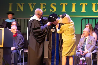 Stephen Younge and President Tessman's mother putting the chain of office on President Tessman