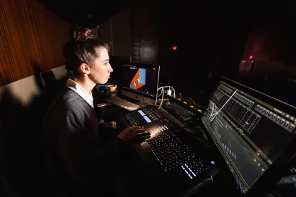 Young woman and theatre sound and light board