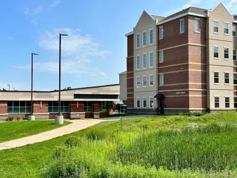 Exterior view of Cedar West, a four story stone and brick building.