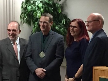 Dr. Dwight Brady accepts the Distinguished Faculty Award alongside President Erickson and two other faculty members.