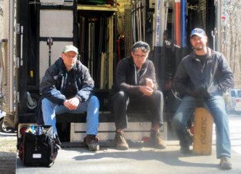 Shevy sitting on the steps with two coworkers