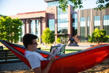 student hammocking on campus
