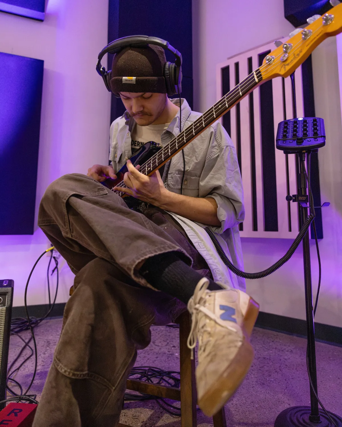 student records a guitar track for album