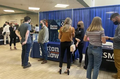 Multiple students chatting with employers at their tables during the Construction Management & Technology Career Fair in 2021