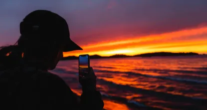 Student taking a picture of the sunset