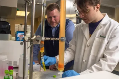 Evan Pratt working in the biochemistry research lab with student, Brennan Cast.