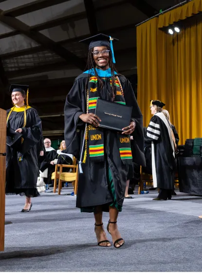 Master's student on stage in hood and regalia