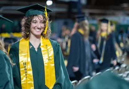 Honors student with their Honors stoll and cord at the commencement ceremony