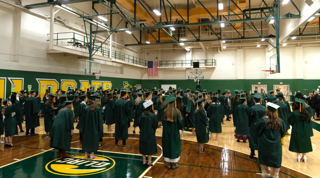 Graduates in Practice Gym gathering before lining up