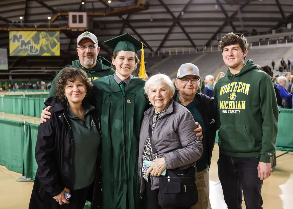 Family surrounding graduate after commencement ceremony