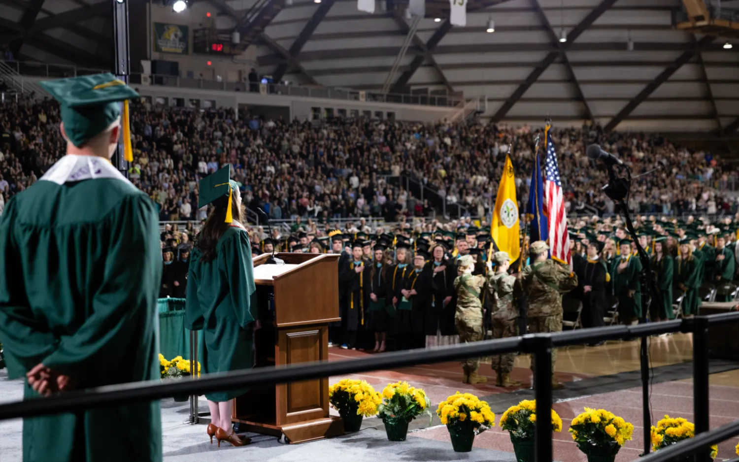 View from stage of a graduate singing the national anthem