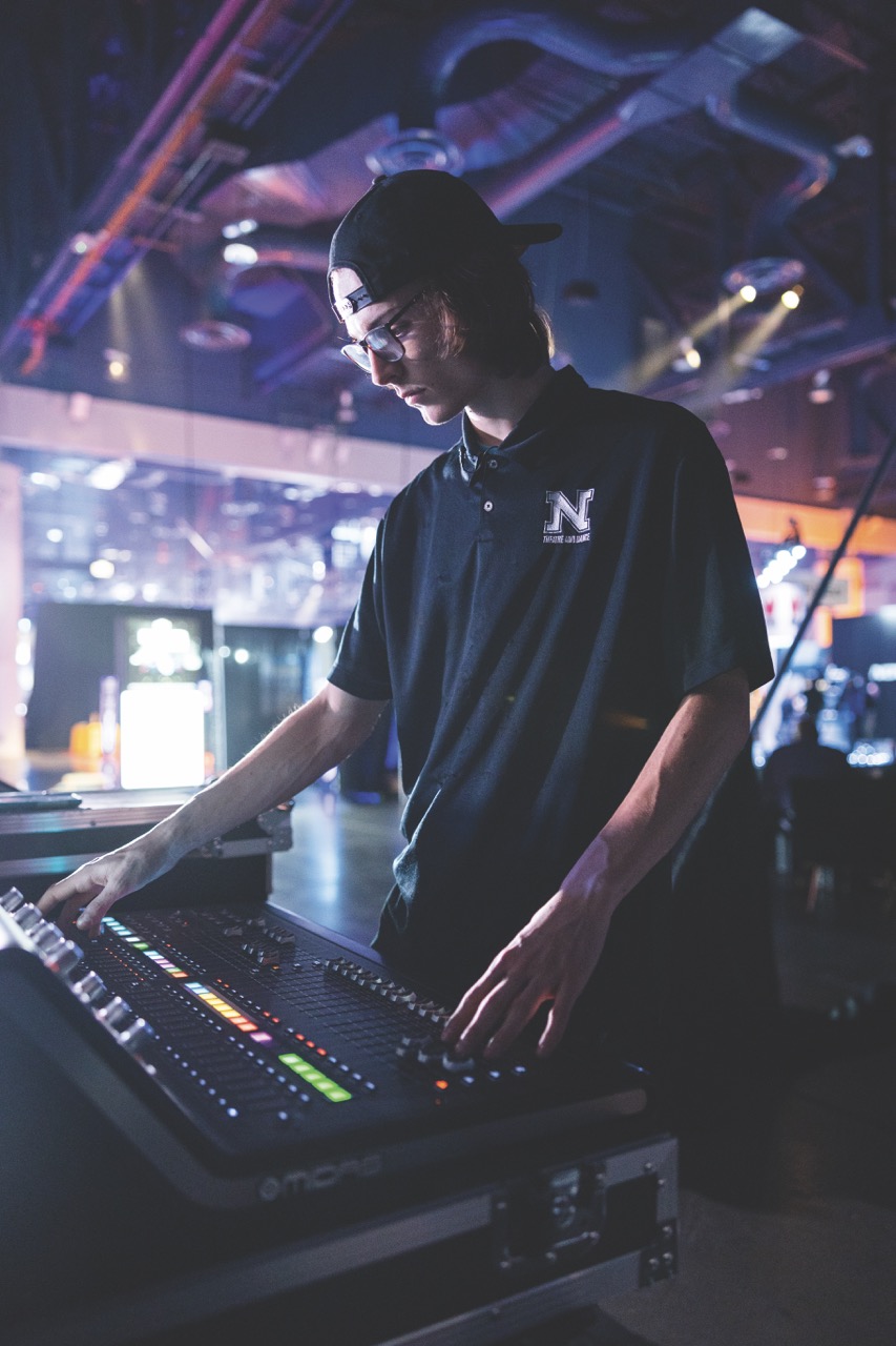 Young man at light board in concert venue