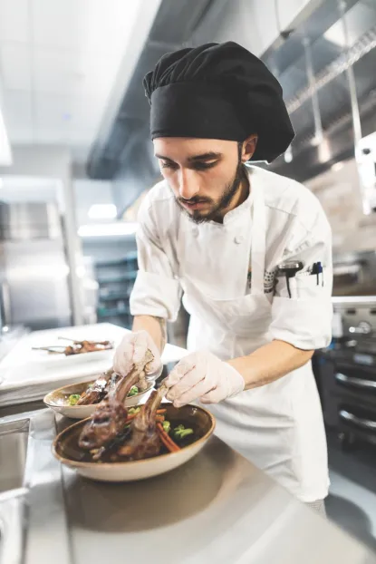 Young male chef preparing meat and vegetables