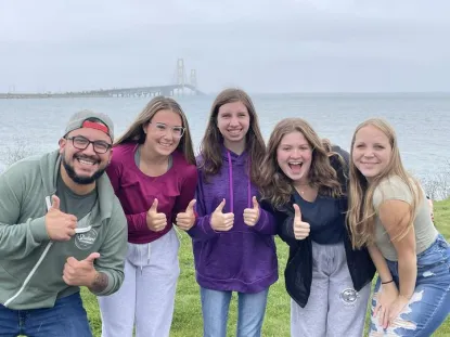 Group of five Marquette Alger Middle College students at the Mackinac Bridge
