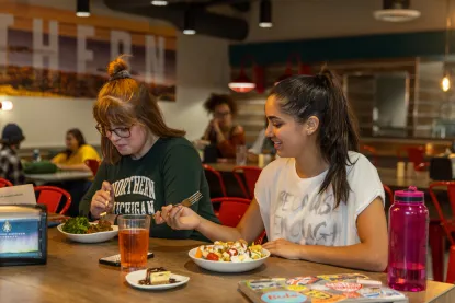Two female students eating at Northern Lights Dining