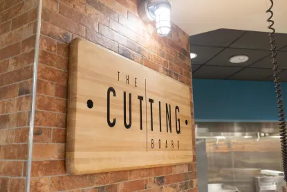 Wooden sign reading The Cutting Board hanging in Northern Lights Dining