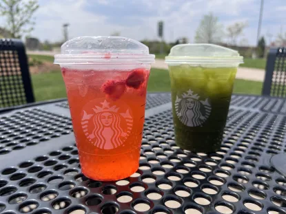 Two Starbucks drinks sitting on an outside table