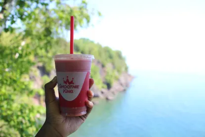 Smoothie being held with the lake and trees in the background